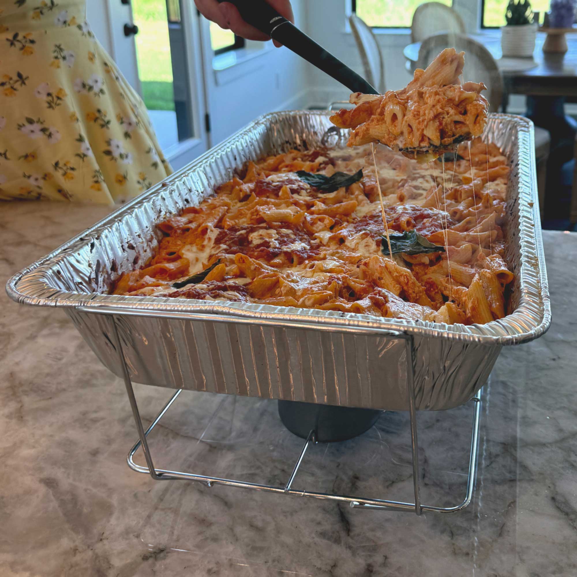 Professional wire chafing rack holding full-size aluminum pan filled with delicious, hot baked ziti – R&S Services